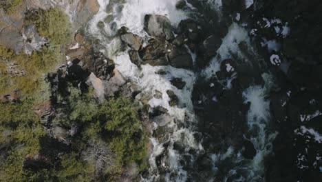 Owen-sound's-rushing-waters-through-rocky-terrain-in-ontario,-bathed-in-daylight,-aerial-view