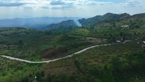 Aerial-approaching-shot-of-wildfire-in-green-landscape-of-Philippines-during-sunny-day