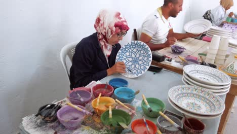 In-Einer-Manufaktur-In-Fez-Bemalen-Handwerker-Tontöpfe-Mit-Traditionellen,-Lebendigen-Marokkanischen-Mustern-Von-Hand-Und-Mit-Viel-Liebe-Zum-Detail.