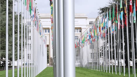 United-Nations-Organization-office-in-Geneva-a-sliding-shot-of-the-garden-with-the-flags-in-Switzerland,-headquarter-of-UN-in-Europe