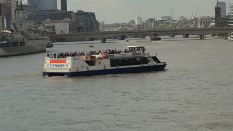 Zeitlupenaufnahme-Eines-Flusskreuzfahrtschiffs-Auf-Der-Themse,-London-Bewegt-Sich-In-Richtung-Tower-Bridge-Pier