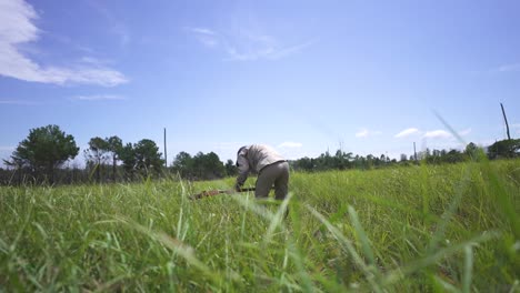 Farmer-Digging-Soil-with-a-Shovel-to-Plant-Trees,-Travelling-Shot