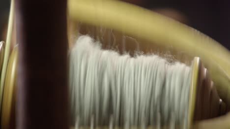 Close-up-spool-spins-wool-yarn-on-antique-Nordic-spinning-wheel