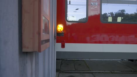 Dusk-scene-of-a-Stuttgart-region-train-at-a-station,-focus-on-the-signal-lamp