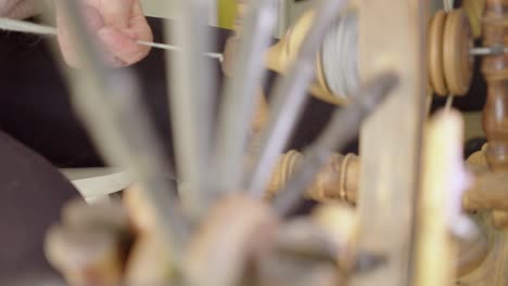 Eine-Kunsthandwerkerin-Führt-Wolle-In-Ein-Traditionelles-Spinnrad-Ein,-Um-Garn-Herzustellen