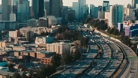 Traffic-of-cars-and-trucks-drive-along-the-I5-interstate-freeway-to-and-from-the-skyscrapers-of-downtown-Seattle-on-a-sunny-afternoon