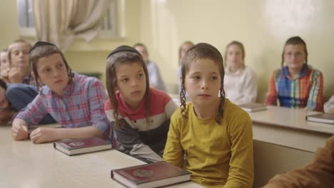 ultra--Orthodox-Jewish-students-with-a-kippahs-stairing-on-the-door