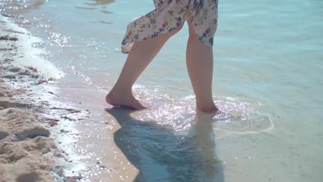 Cierra-Las-Piernas-De-Una-Mujer-Caminando-Y-Camina-Hacia-El-Hermoso-Mar-En-La-Playa-En-Verano-Lento