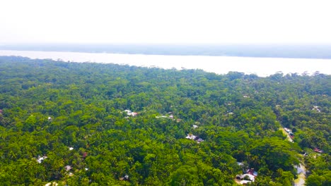 Pequeño-Pueblo-Africano-En-Un-Denso-Bosque-Junto-A-Un-Gran-Río,-Vista-Aérea-De-360-Grados-A-La-Derecha