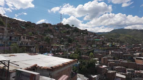 Hillside-homes-in-Comuna-13-favela-under-the-blue-skies-of-Medellín,-Colombia
