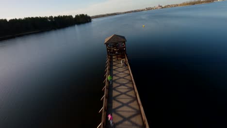 FPV-drone-shot-flying-overlooking-people-and-a-pier,-in-sunny-Mazury,-Poland