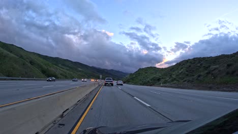 Paseo-Al-Atardecer-Por-La-Autopista-14-De-CA-Cerca-De-Rosamond-Con-Tráfico-Y-Cielos-Nublados,-Gran-Angular,-Timelapse