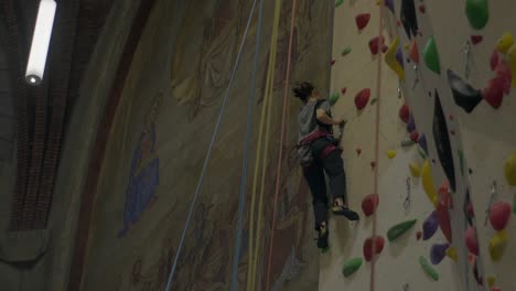 Climber-ascends-indoor-wall-in-historic-church-setting