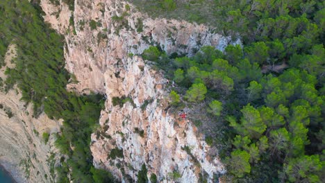 Couple-picnic-on-cliff-edge-with-a-view-of-the-green-landscape-during-sunset-in-ibiza