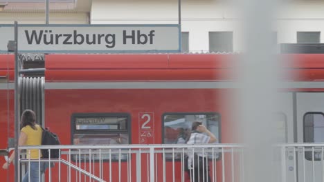 Roter-Zug-Der-Deutschen-Bahn-Am-Würzburger-Hauptbahnhof,-Aufgenommen-Mit-Fokus-Auf-Beschilderung-Und-Details-Des-Waggons