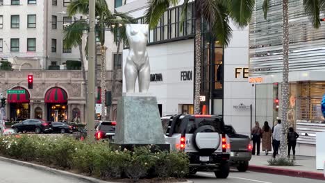 Estatua-Del-Torso-De-Beverly-Hills-Por-Robert-Graham-En-Rodeo-Drive-Con-Tráfico-Pasando