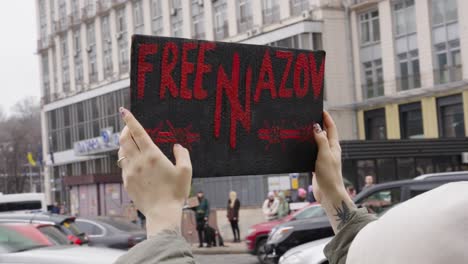 Demonstrant-Hält-Schwarzes-Plakat-Hoch,-Das-Free-Azov-Unterstützt