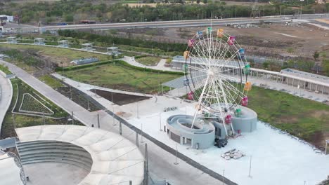 The-drone-camera-is-panning-upwards-and-a-large-giant-wheel-is-visible