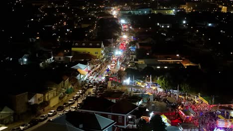 Luces-Brillantes-Brillan-Y-Parpadean-Durante-El-Desfile-Nocturno-De-Carnaval,-órbita-Aérea