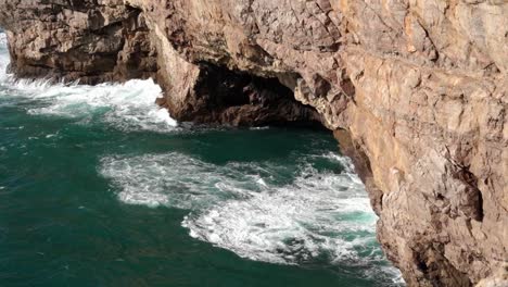Beautiful-Coastal-Rock-Formations-And-Crashing-Sea-Waves-Under-The-Sagres-Fortress-In-Vila-do-Bispo,-Algarve,-Portugal