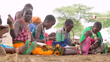 Amboseli,-Kenya---April-18,-2024:-A-group-of-Masai-women-make-traditional-handmade-jewelry-using-strings-and-beads-as-a-source-of-sustainable-income-during-droughts-in-Amboseli,-Kenya,-East-Africa