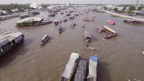 Aerial-view-of-boats-riding-up-and-down-the-Can-Tho-river-at-a-floating-market-at-Cai-Rang,-Vietnam,-Asia