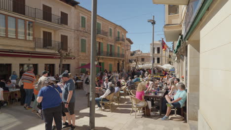 Bustling-outdoor-market-in-sunny-Santanyi,-Mallorca-with-lively-crowds