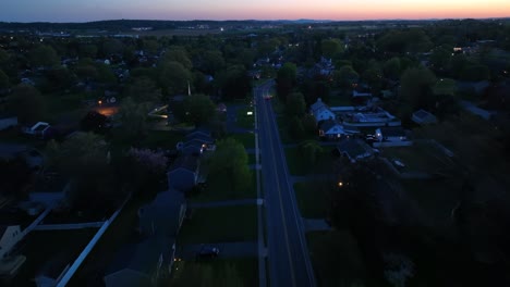 Birds-eye-flight-over-main-street-of-american-town-at-dusk-after-sunset