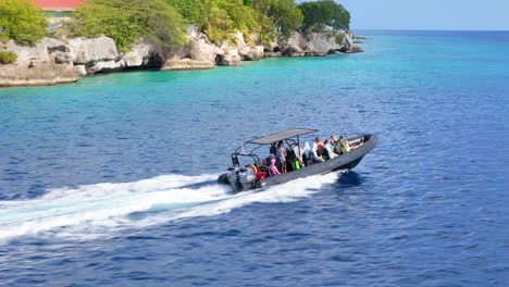 Inflatable-dive-tour-boat-glides-across-ocean-water-as-they-approach-snorkel-site