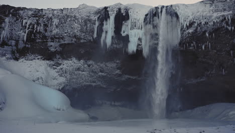 Cascada-De-Seljalandsfoss-En-Islandia-Establecida-En-Cámara-Lenta-Invierno-Congelado-Paisaje-Blanco-Como-La-Nieve-Famoso-Punto-De-Referencia