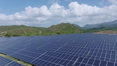 Drohne-Fliegt-In-Geringer-Höhe-über-Paneelen-In-Einem-Von-Ländlicher-Landschaft-Umgebenen-Photovoltaikpark