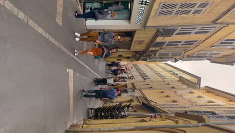 Turistas-Y-Lugareños-Pasean-Por-Una-Encantadora-Calle-En-Aix-en-Provence,-Francia,-Una-Cafetería-Cercana,-Durante-El-Día