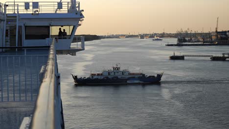 Un-Pequeño-Ferry-Con-Pasajeros-Y-Automóviles-Pasa-Junto-A-Un-Barco-Grande