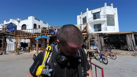 Turista-Con-Equipo-De-Buceo,-Preparándose-Para-Bucear-En-Dahab,-Egipto