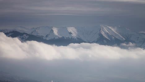 Montañas-Cubiertas-De-Nieve-Se-Elevan-Por-Encima-De-Las-Densas-Nubes-Blancas