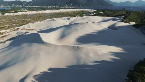 The-majestic-sand-dunes-of-Joaquina-in-Florianopolis,-Brazil,-stand-tall-and-impressive,-sculpted-by-nature's-forces-over-time