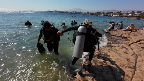 Scuba-Divers-Preparing-to-Dive-in-the-Resort-Town-of-Dahab,-Sinai-Peninsula,-Egypt---Slow-Motion