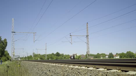 Hochgeschwindigkeitszug-Rast-An-Einem-Sonnigen-Tag-Entlang-Der-Gleise,-Bewegungsunschärfe-Erfasst-Die-Schnelle-Bewegung