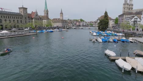 Langsam-Vorwärts-Bewegte-Drohnenaufnahme,-Die-Eine-Party-Auf-Einem-Pier-Und-Die-Architektur-Der-Altstadt-Entlang-Des-Flusses-Zeigt