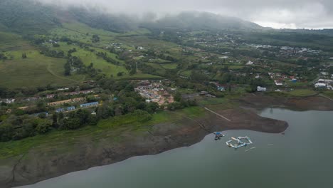 Flying-Over-Lake-with-Clouds-and-Mountains-in-the-Background