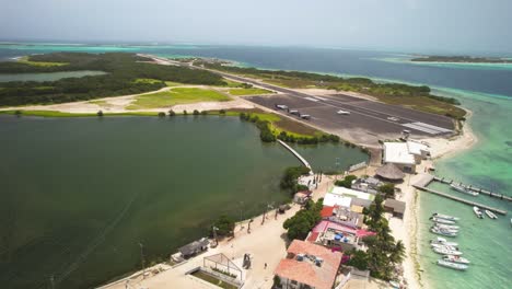 Los-roques'-airstrip-in-venezuela-with-clear-waters-and-boats,-bright-day,-aerial-view