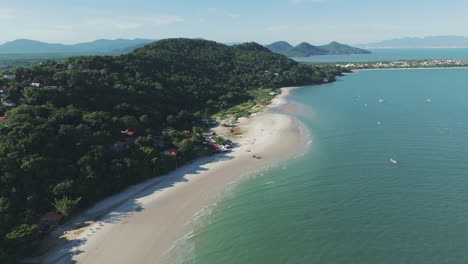 Bird's-eye-view-captures-the-serene-Forte-Beach-in-Santa-Catarina-along-the-Brazilian-coast,-with-its-calm,-emerald-green-waters-creating-a-tranquil-and-inviting-atmosphere