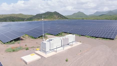 Battery-storage-system-on-solar-farm-surrounded-by-PV-panels,-Bani