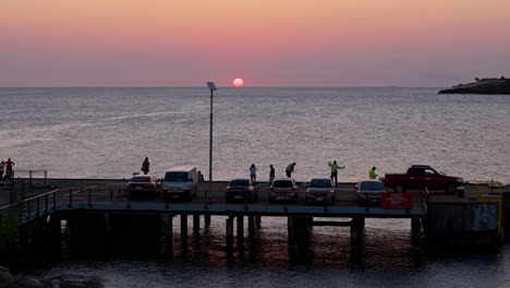 Aerial-dolly-as-fishermen-at-sunset-on-docks-enjoying-golden-hour