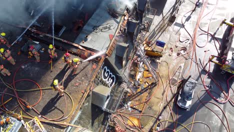 Bomberos-Extinguiendo-El-Fuego-En-La-Azotea-Desde-Un-Dron-Aéreo-Vista-De-Arriba-Hacia-Abajo-En-Montreal,-Canadá