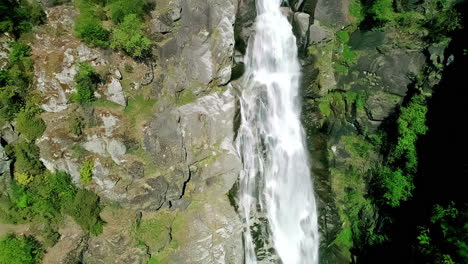 Following-water-as-it-cascades-along-a-cliff-at-a-waterfall-in-Norway---aerial