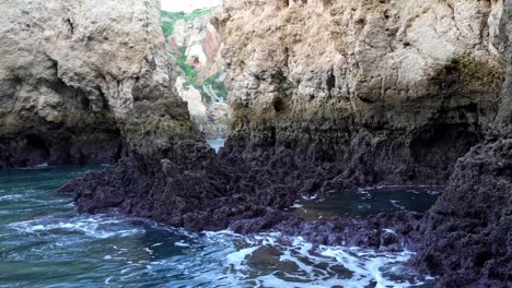 Dark-And-Jagged-Rock-Formations-Along-The-Rugged-Coastline-Of-Lagos,-Algarve,-Portugal