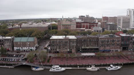 Toma-Aérea-Baja-Del-Histórico-Distrito-Riverwalk-En-El-Centro-De-Savannah,-Georgia