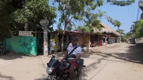 Pan-shot-of-Picturesque-street-from-Palomino-village,-Local-business-stores,-Caribbean-coastline,-Colombia