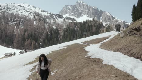 Mujer-Haciendo-Trekking-En-Una-Ladera-Nevada-En-La-Cordillera-De-Dolomitas-En-Tirol-Del-Sur,-Italia